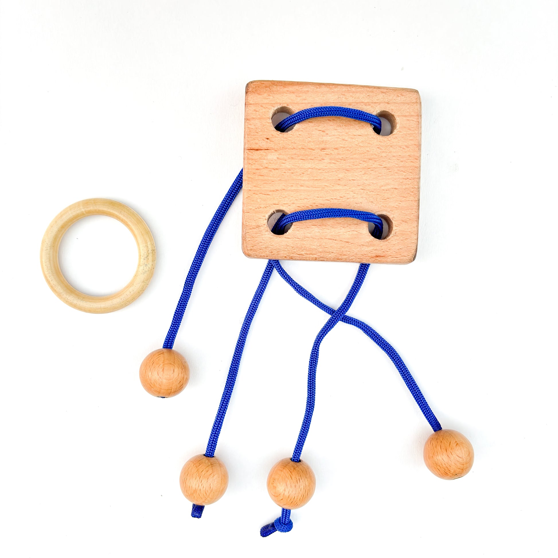 Wooden disentanglement String puzzle with blue rope, ball, and ring on white background