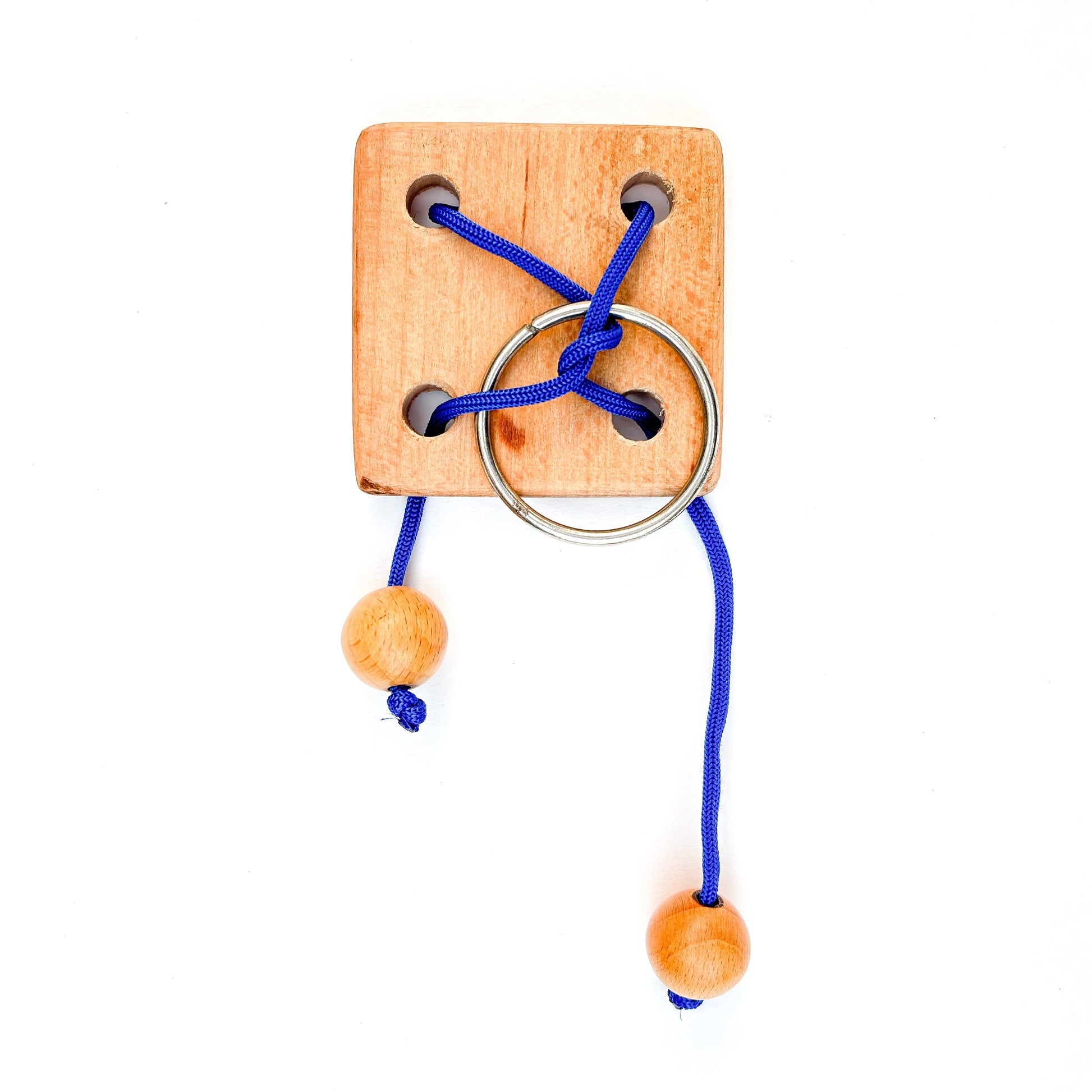 Wooden puzzle with blue rope and ring on white background. This classic brain teaser toy challenges players to manipulate the rope to separate the ring from the puzzle.