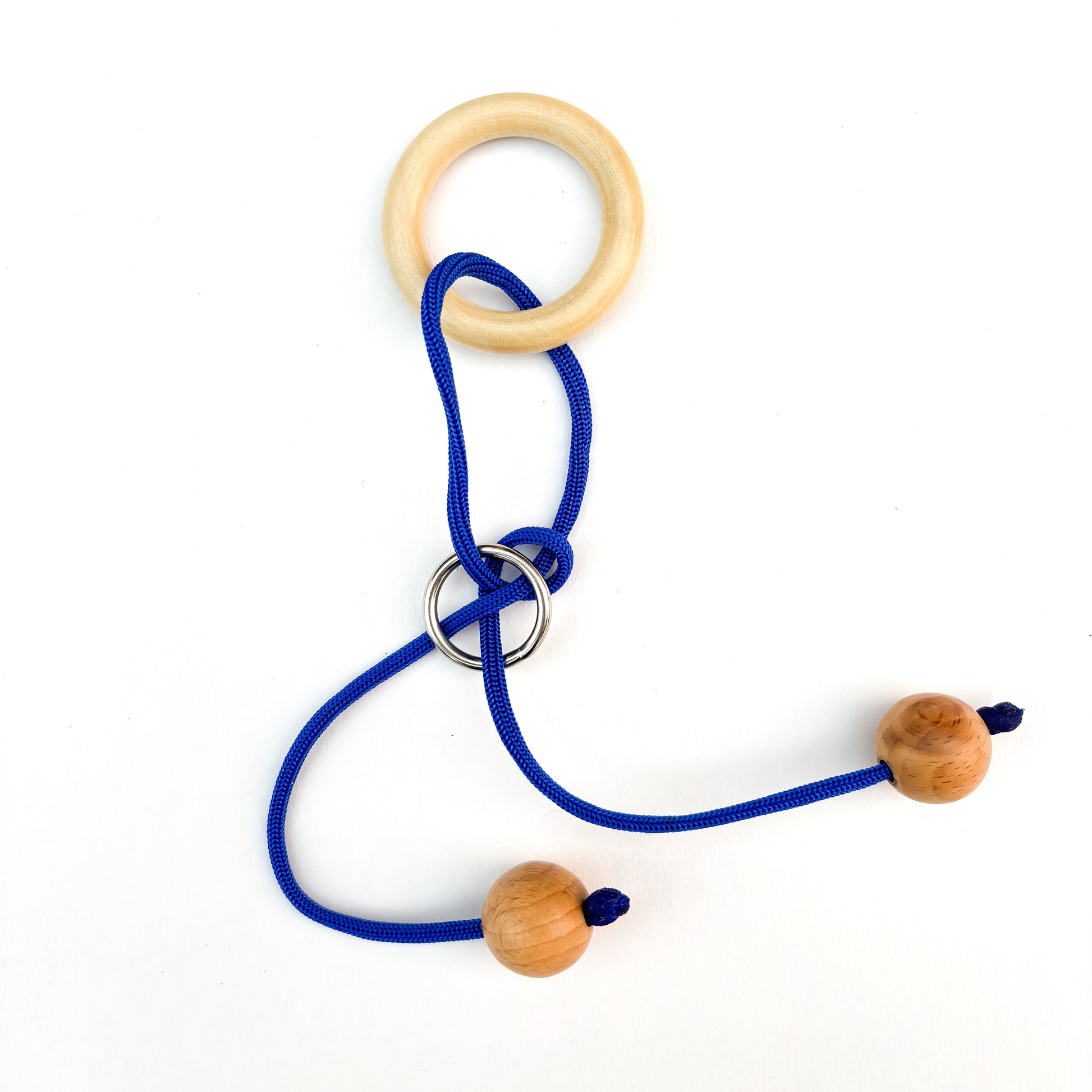 Wooden ring puzzle with blue rope on a white background. This classic brain teaser toy challenges players to manipulate the rope to separate the ring from the puzzle.