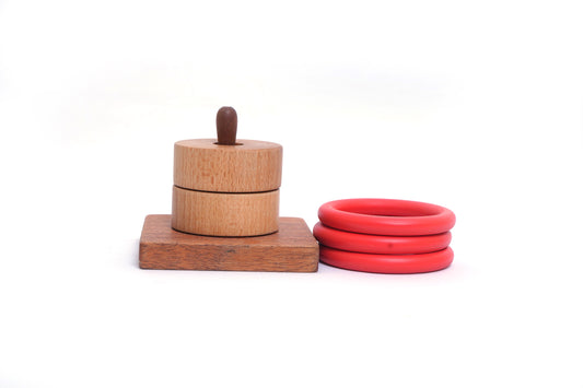 Wooden toy with three red rings stacked on a central post on a white background