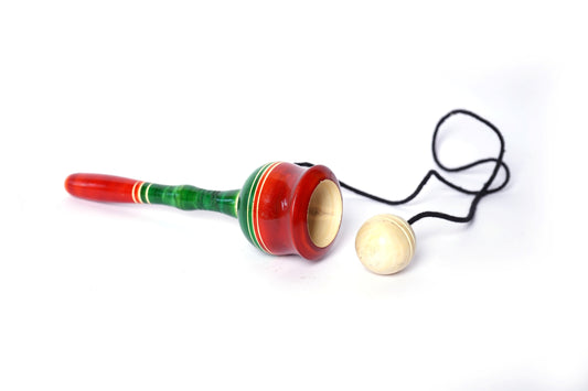  Wooden cup and ball toy with a red string attached to a yellow cup and a green ball inside. This classic children's toy helps toddlers develop motor skills and hand-eye coordination. 